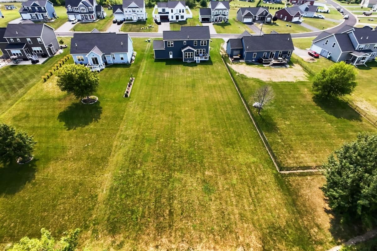 Aerial of open building lots behind new homes